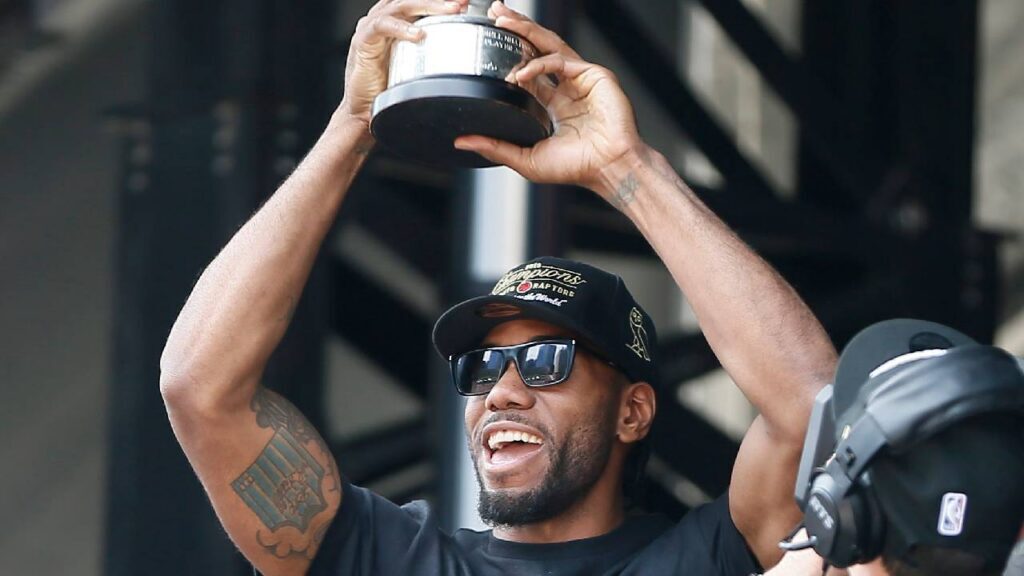 Kawhi Leonard displays the NBA Finals MVP trophy during Toronto’s championship rally in Kawhi Leonard Contract Extension coverage.