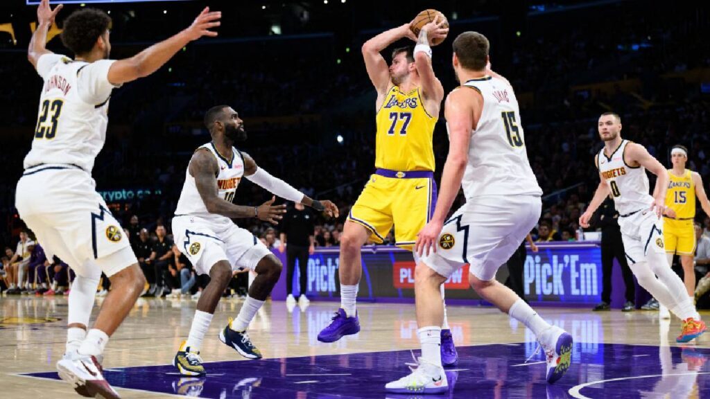 Los Angeles Lakers guard Luka Doncic (77) looks to pass while under pressure from Denver Nuggets center Nikola Jokic (15) and guard Tim Hardaway Jr. (10) during the first half at Crypto.com Arena.