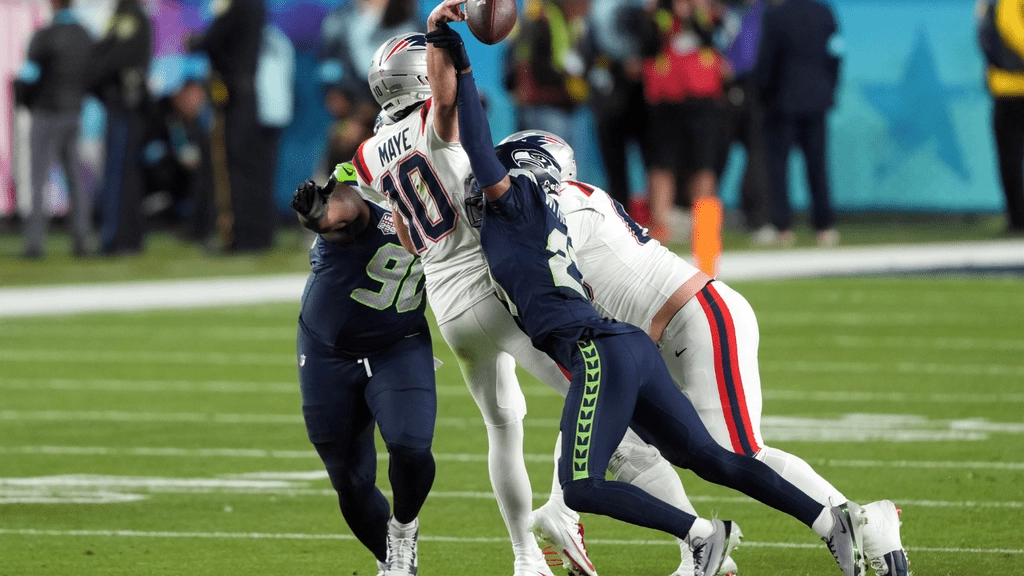 Feb 8, 2026; Santa Clara, CA, USA; Seattle Seahawks cornerback Devon Witherspoon (center right) forces a fumble by New England Patriots quarterback Drake Maye (10) during the fourth quarter in Super Bowl LX at Levi's Stadium. Mandatory Credit: Darren Yamashita-Imagn Images