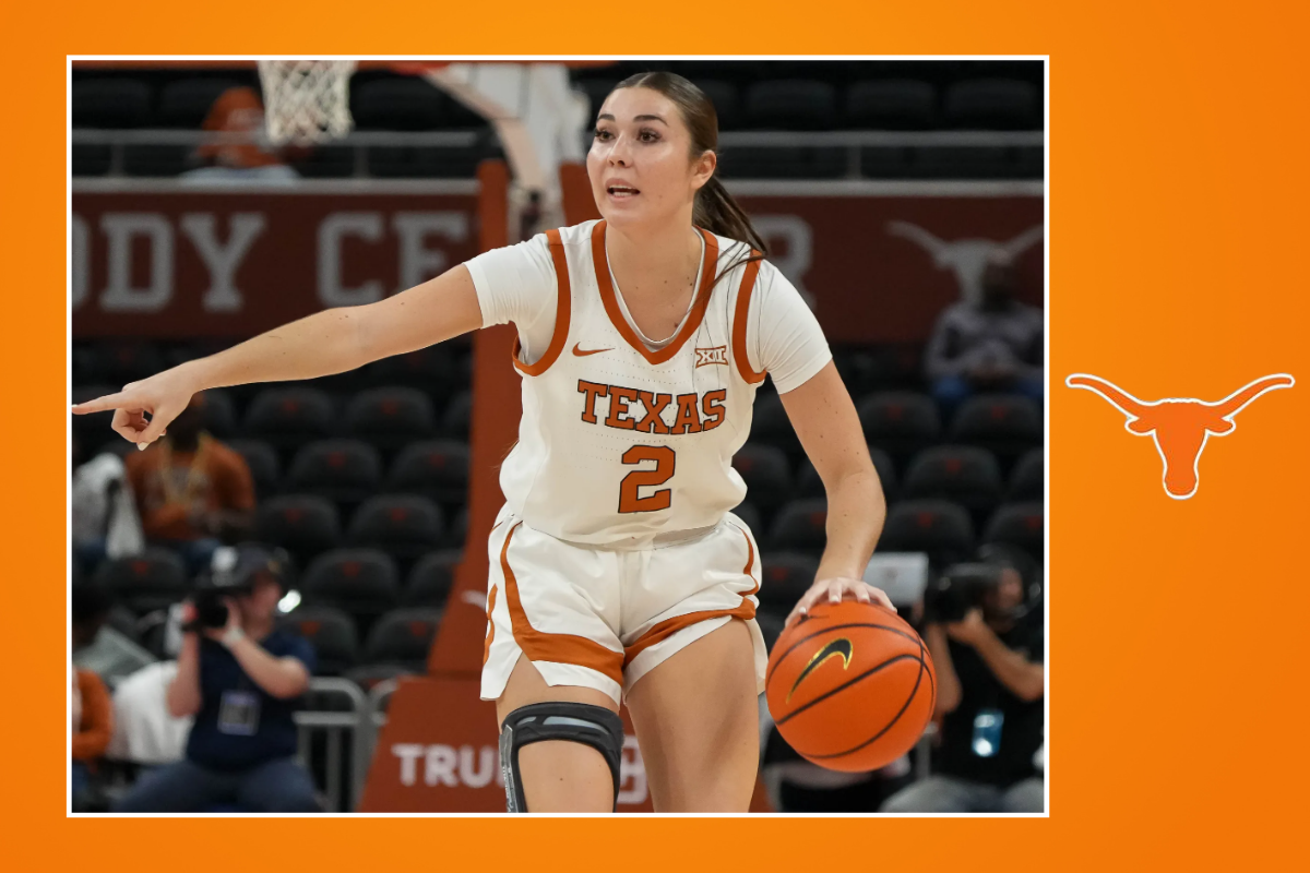 A Texas Longhorns women's basketball player wearing a white No. 2 jersey dribbles the ball up the court while pointing and directing her teammates during a game.