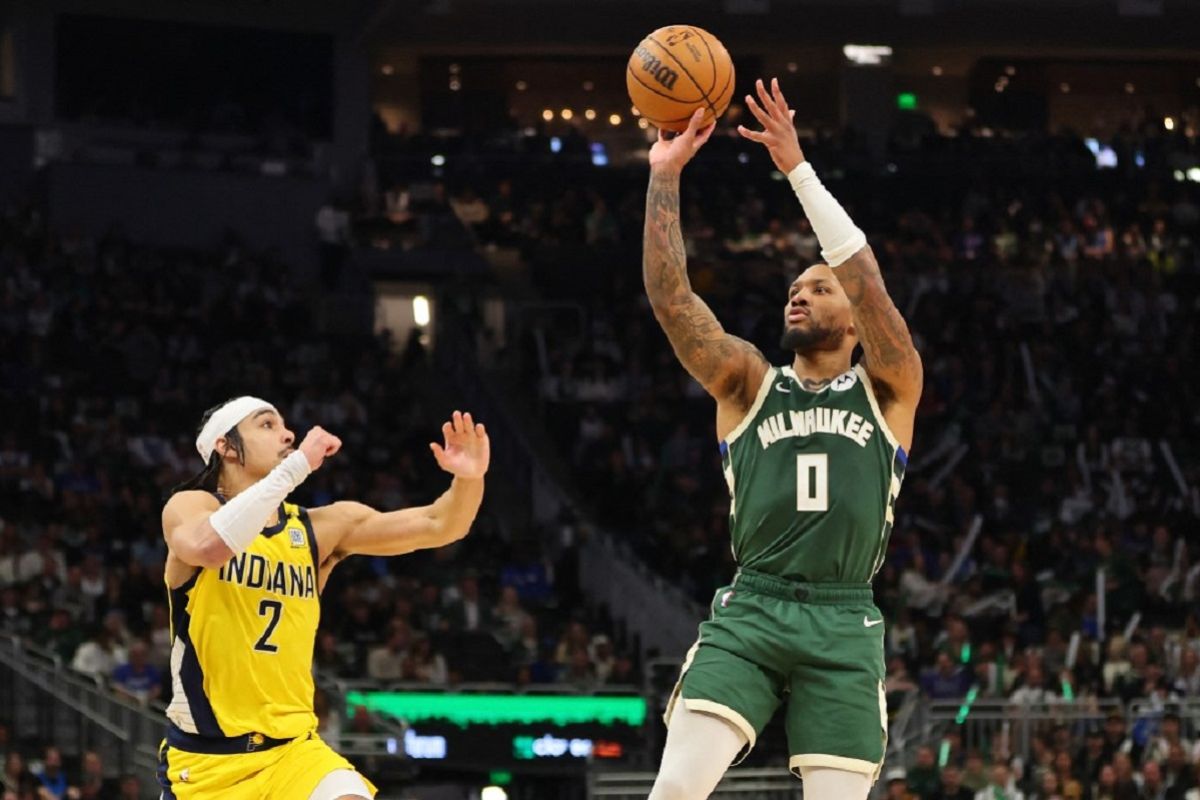 Number 0, Damian Lillard, of the Milwaukee Bucks shoots a jump shot over Andrew Nembhard of the Indiana Pacers.