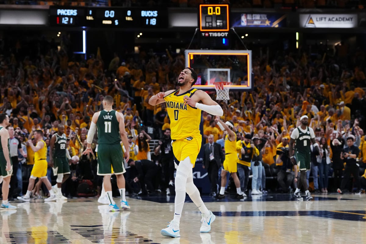 Tyrese Haliburton, number 0 of the Indiana Pacers, tugs on his jersey in celebration as they defeat the Milwaukee Bucks