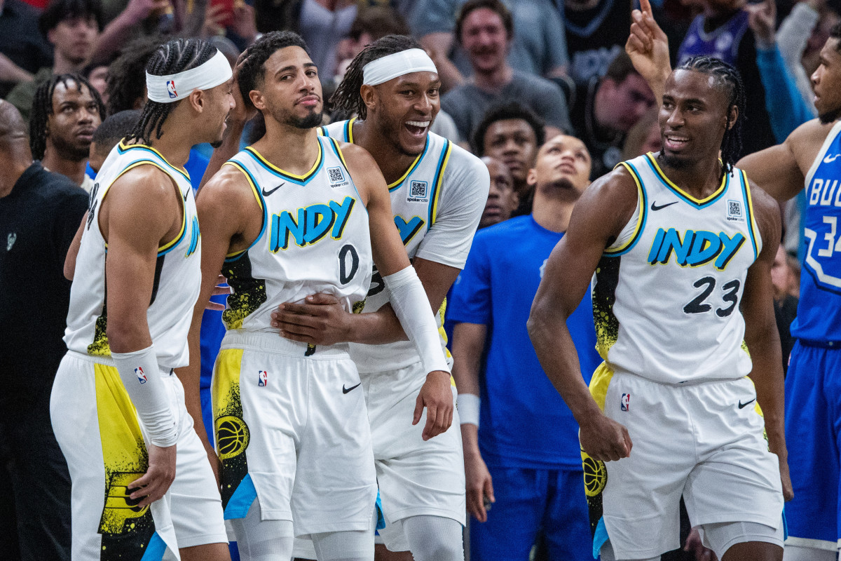 Tyrese Haliburton of the Indiana Pacers is hugged by teammate Myles Turner while two other teammates stand by his side