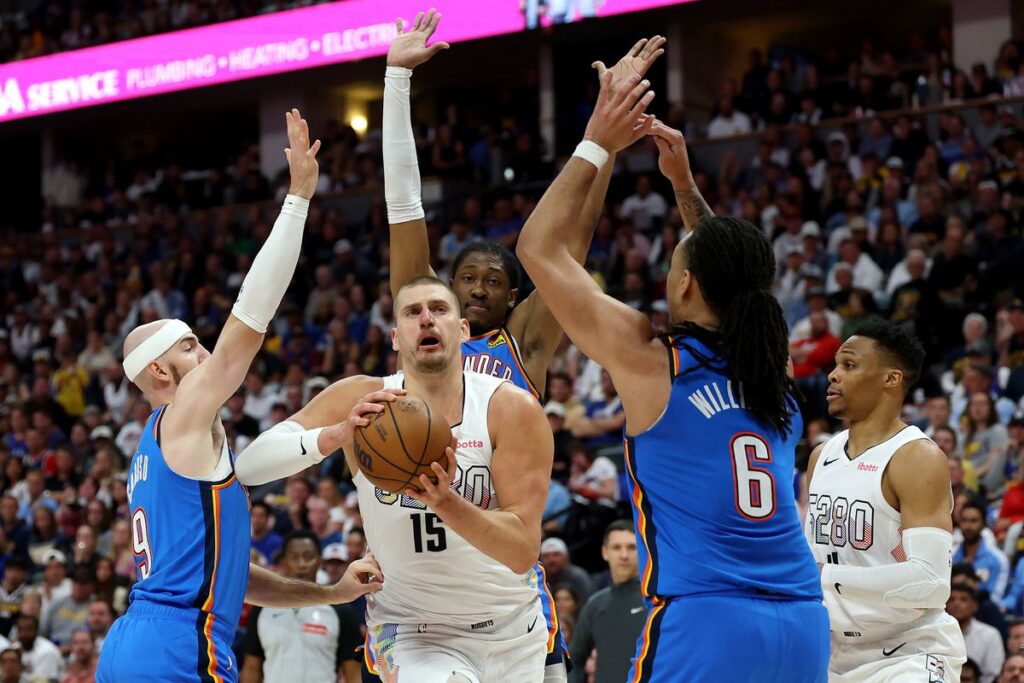Thunder defense surround Nuggets star Nikola Jokic in the paint.