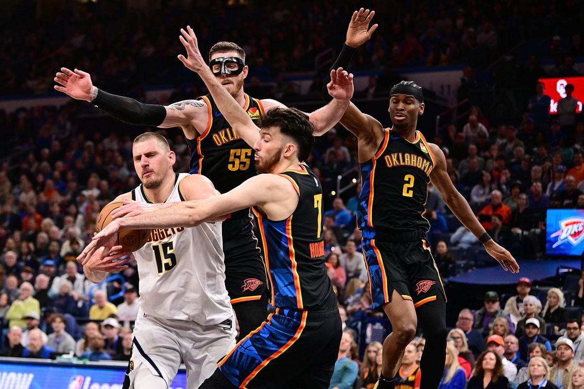 Nikola Jokic, of the Denver Nuggets, protects the basketball while three OKC Thunder defenders surround him.