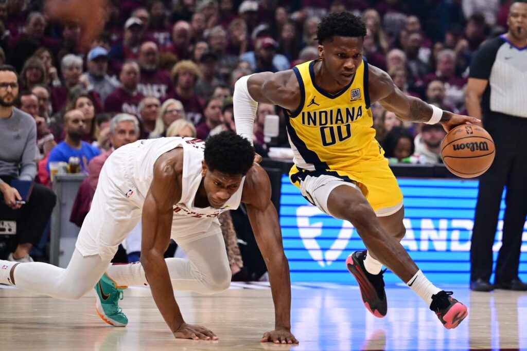 In a Pacers vs. Cavaliers matchup, Benedict Mathurin drives past a Cleveland player, making him touch the ground with both hands.