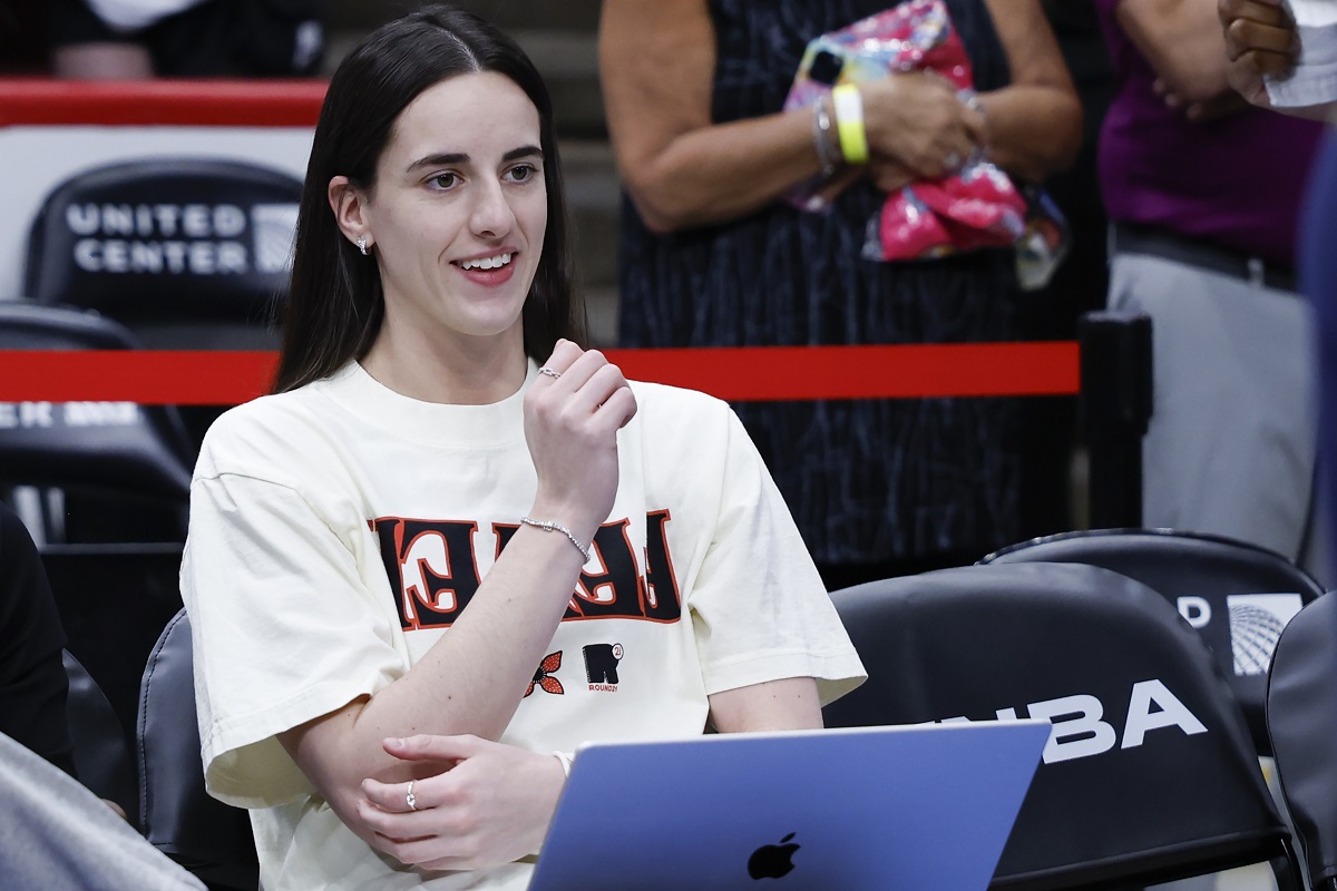 Caitlin Clark sits on the bench while her Indiana Fever warm up for a game against the Chicago Sky.