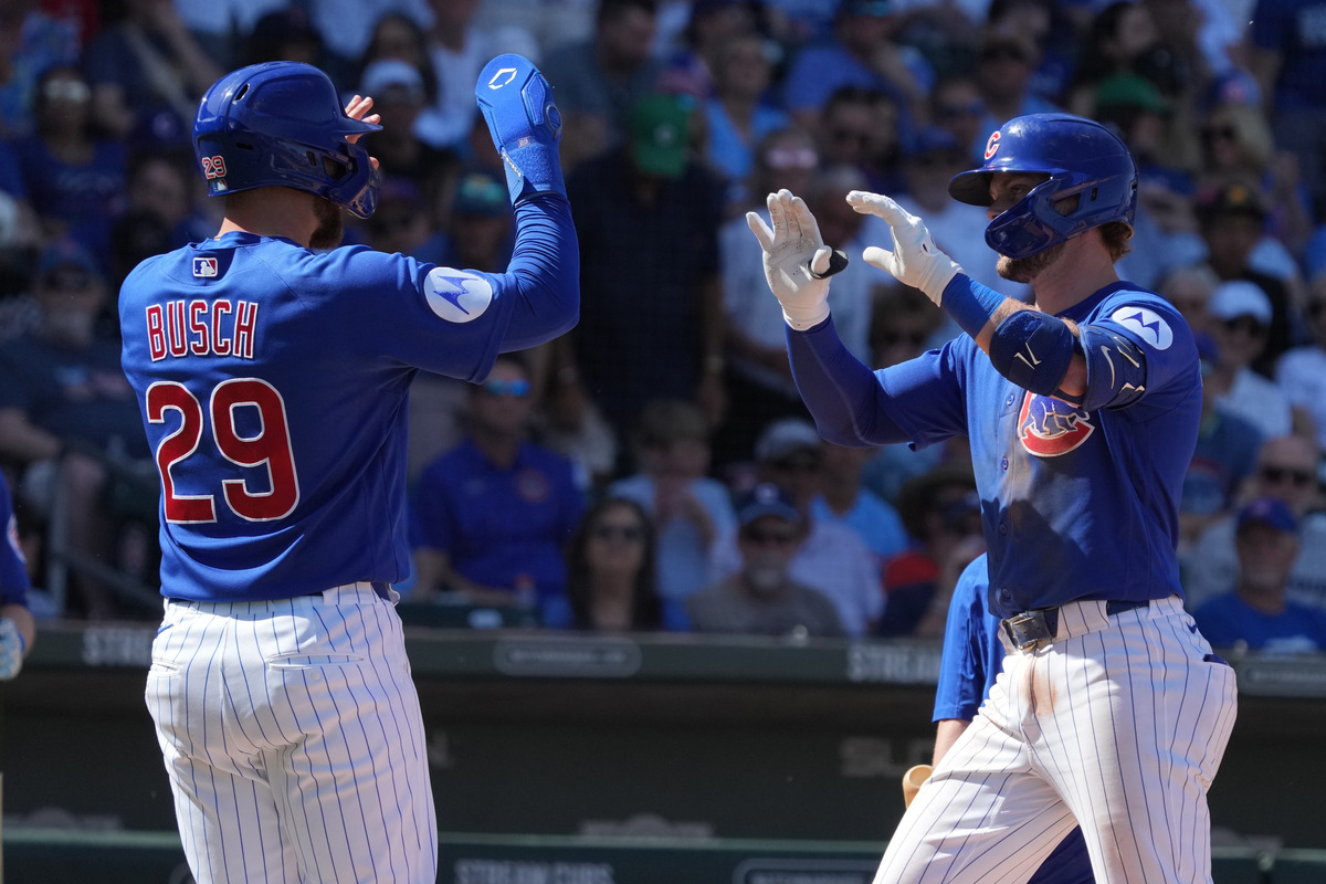 Mar 15, 2026; Mesa, Arizona, USA; Chicago Nico Hoerner celebrates a Cubs' home run with Michael Busch.