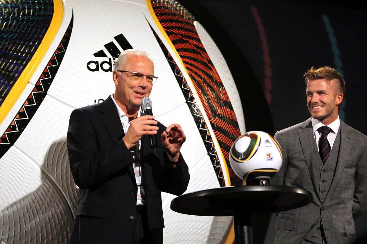 Franz Beckenbauer stands with David Beckham during the 2010 FIFA World Cup ceremony.