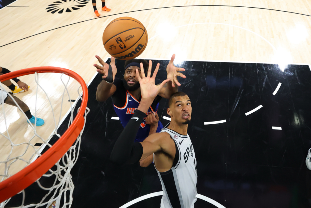 Jun 13, 2026; San Antonio, Texas, USA; New York Knicks center Mitchell Robinson (23) and San Antonio Spurs forward Victor Wembanyama (1) battle for a rebound during game five of the 2026 NBA Finals at Frost Bank Center. Mandatory Credit: Geoff Burke-Imagn Images