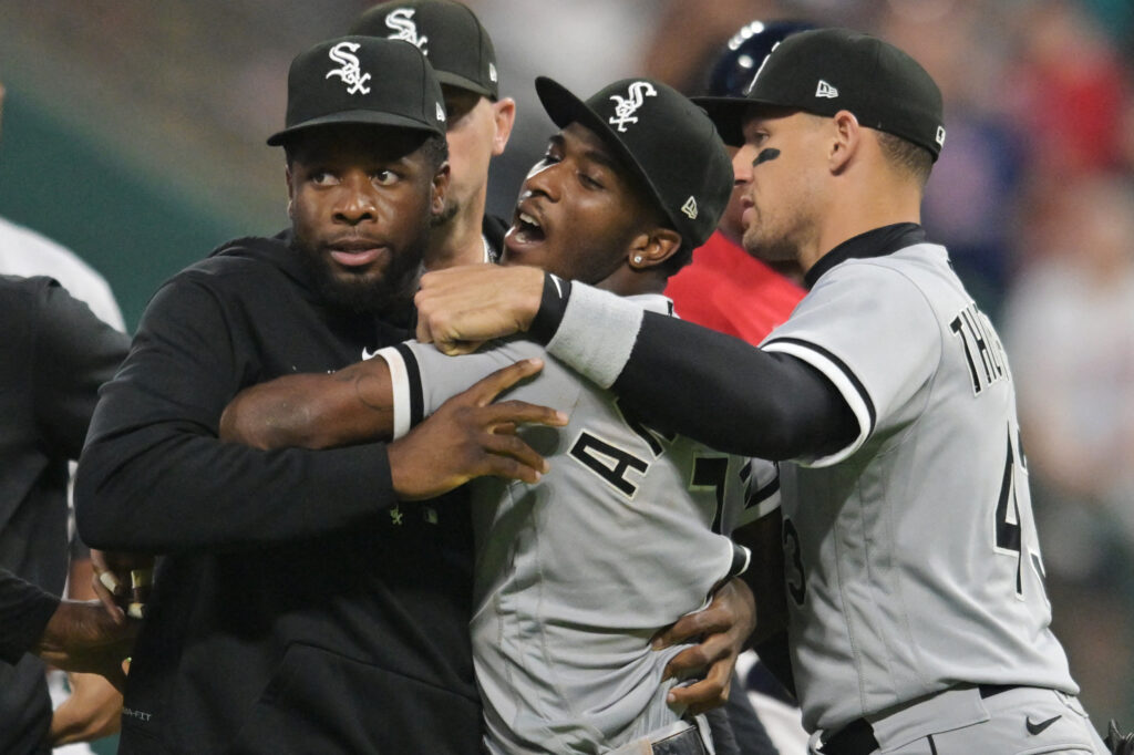 Tim Anderson being helped up by teammates.